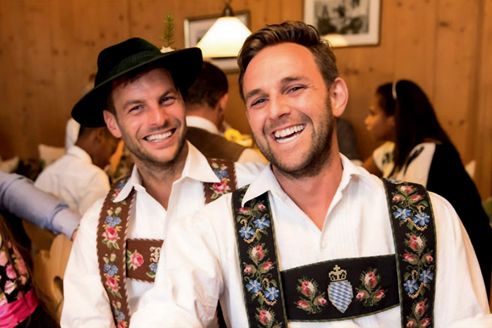 Junge Männer feiern ausgelassen in bayrischer Tracht auf der Stadlbergalm